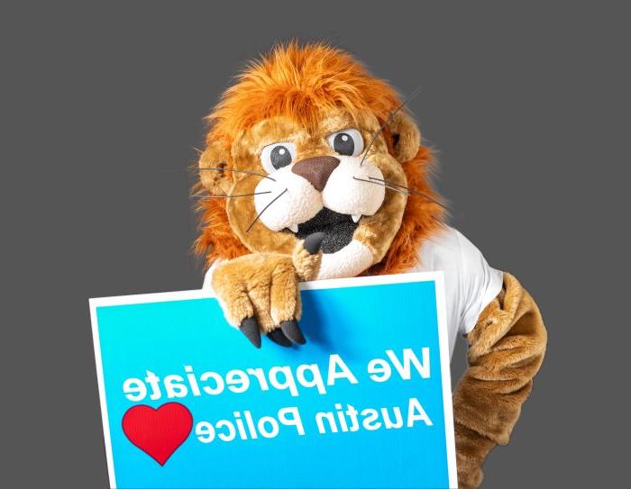 The Lucky Lion mascot holds a sign saying "We Appreciate Austin Police"